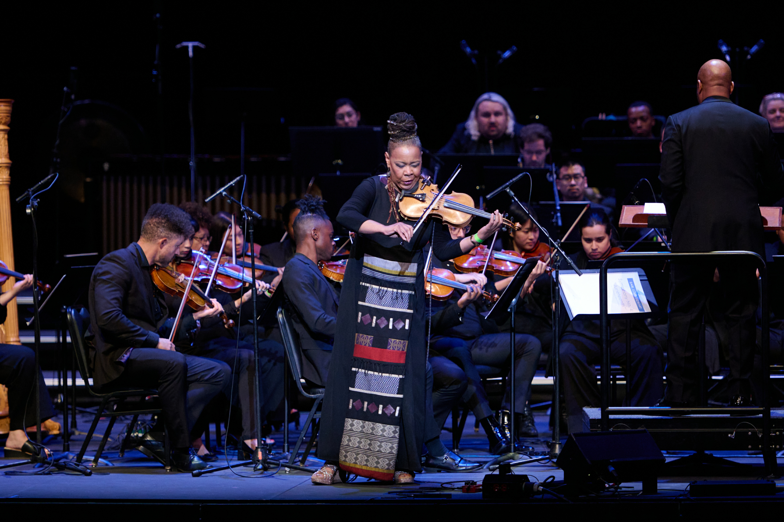 Juneteenth Day woman playing the violin with a band behind her on stage