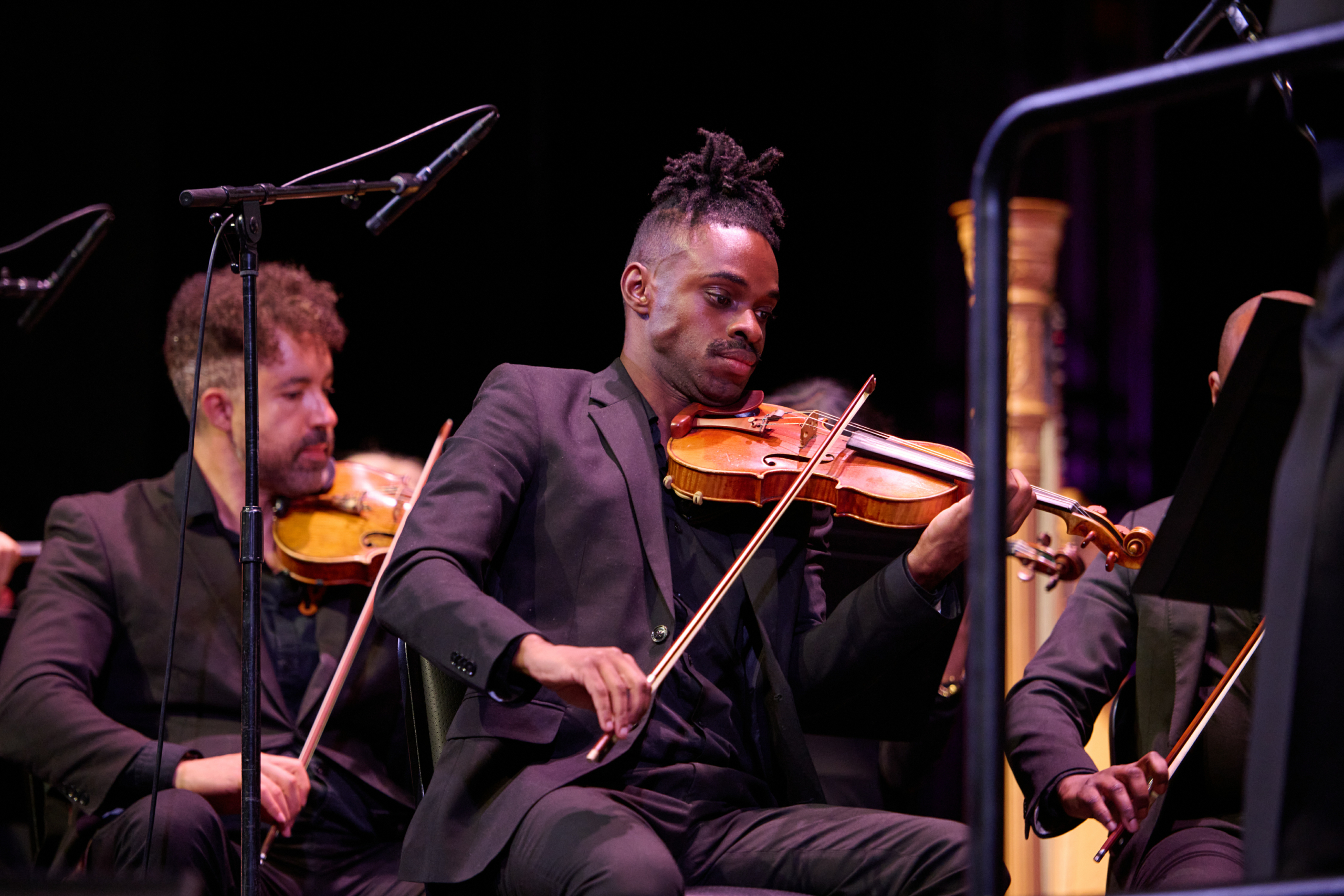 Juneteenth Day man playing violin on stage with his bandmates